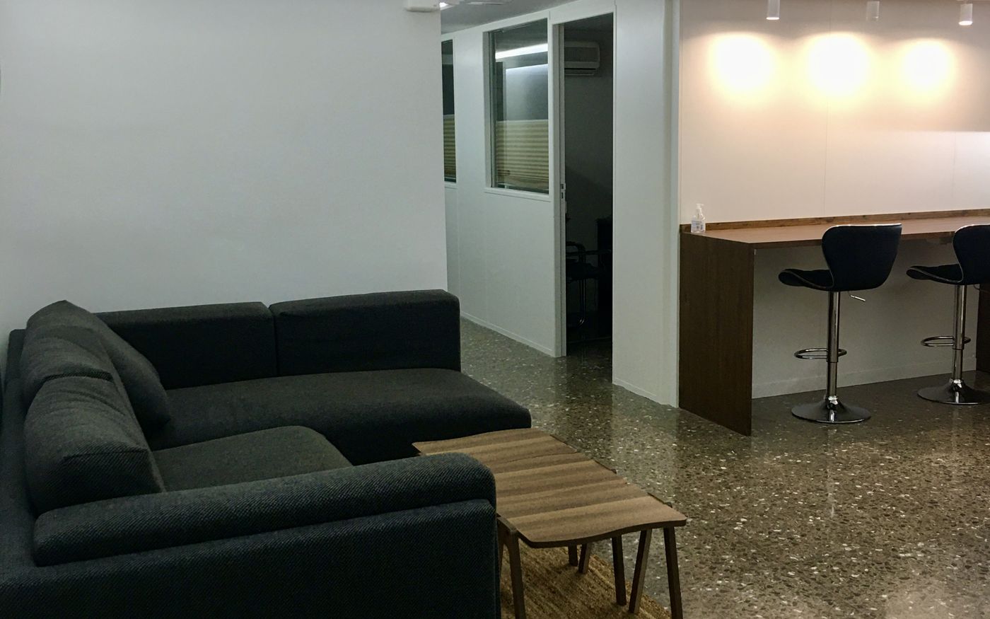Zona comuna de WorkSpace.Cat amb sofà, taula alta i cafetera